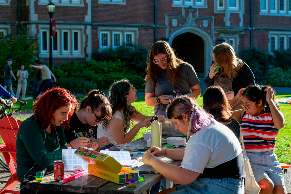 A group of students participating in a shared activity at a picnic table.